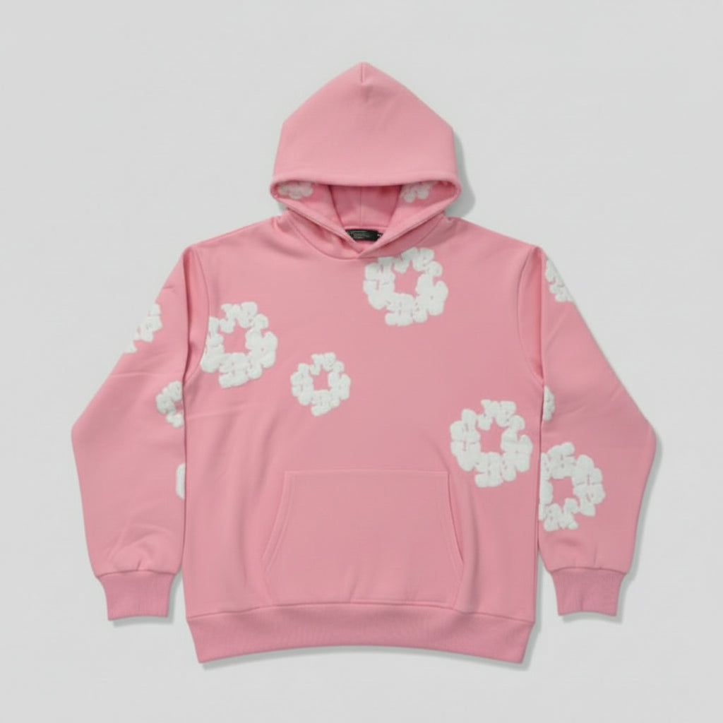 Pink hoodie with white floral patterns on a gray surface